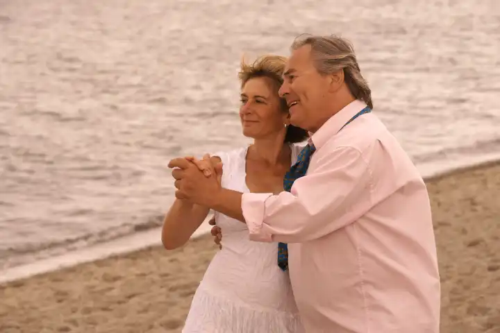 Old couple dance on the beach