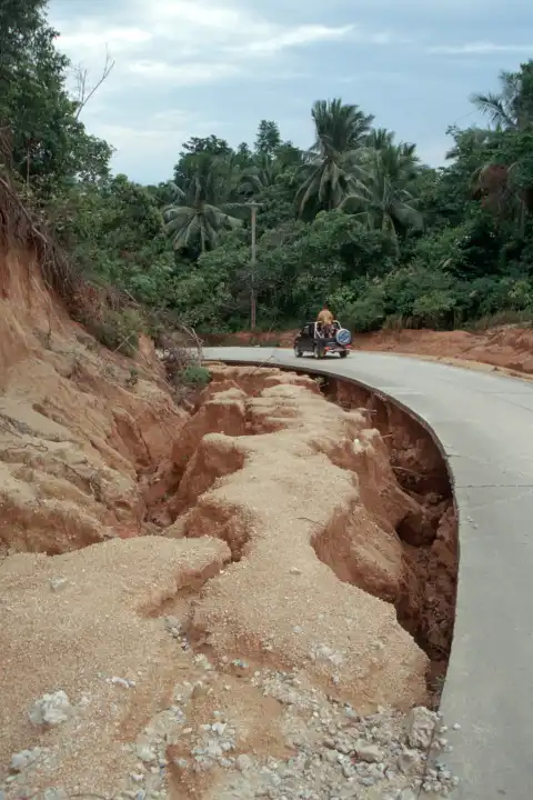 Unterspülte Strasse auf der Insel Ko Phangan, Thailand