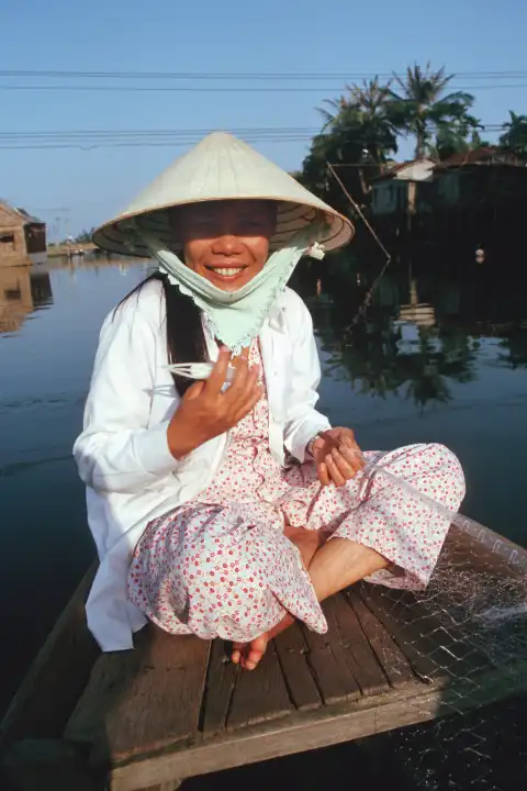 Vietnamesische Frau flechtet ein Fischernetz in Hoi An