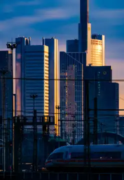 Skyline von Frankfurt am Main im Morgenlicht mit ICE-Zug, der den Hauptbahnhof verlässt