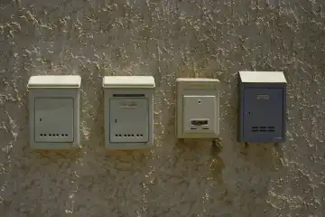 4 post boxes on a wall