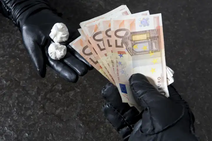 2 Hände in schwarzen Lederhandschuhe tauschen Rauschgift gegen Geld