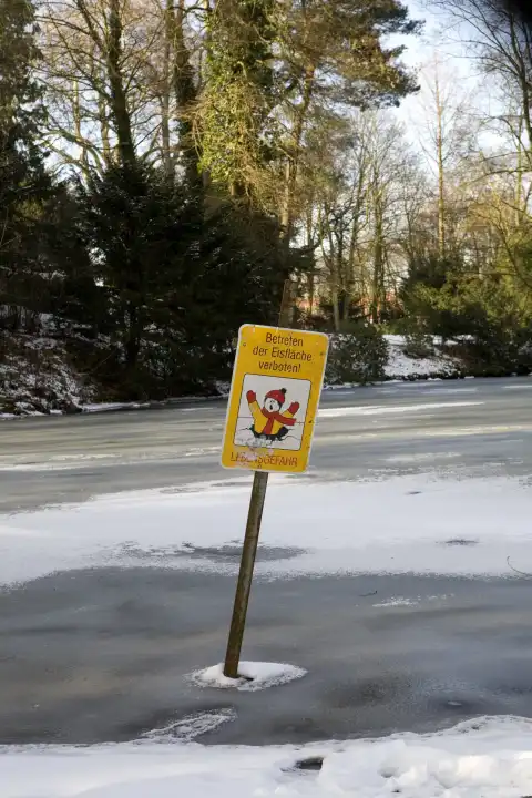 Warnschild an einem zugefrorenen Gewässer