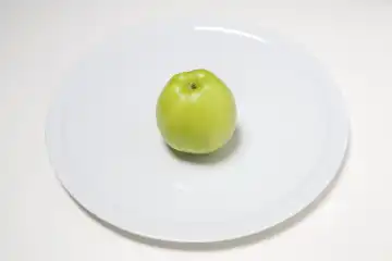 einzelner Apfel Granny Smith auf weiÃŸem Teller