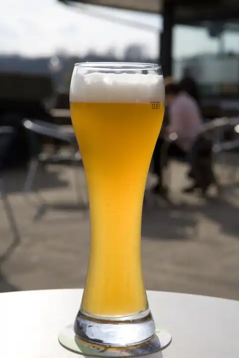 glass filled up with wheat beer on table