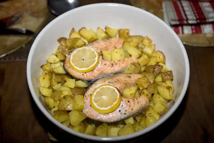 salmon steaks and braised potatoes in a gratin dish