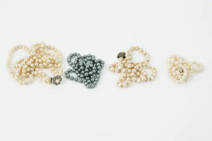 four different pearl chains against white background
