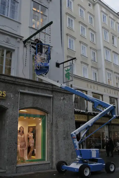 Man Hanging Christmas Lights, Haus Steindl, Salzburg, Austria, Europe