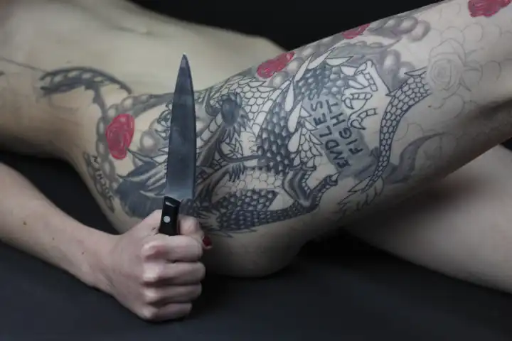 Tattooed woman with knife