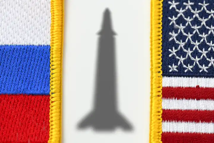Shadow of a missile between the flags of the USA and Russia, termination of the INF Treaty