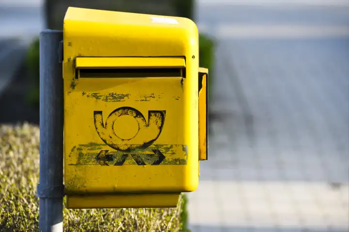 Verblichenes Zeichen der Deutschen Post auf einem Briefkasten