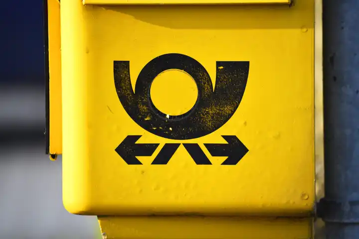 Post horn sign of the Deutsche Post on a mailbox