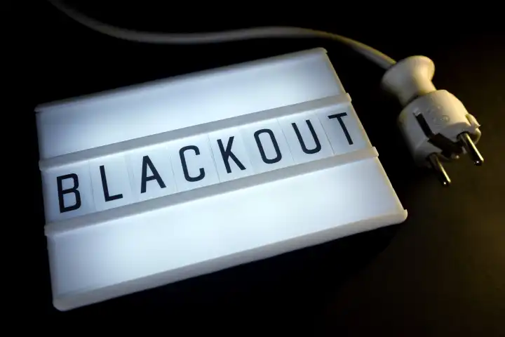 Leuchttafel mit der Aufschrift Blackout und Stecker, Symbolfoto für großflächigen Stromausfall