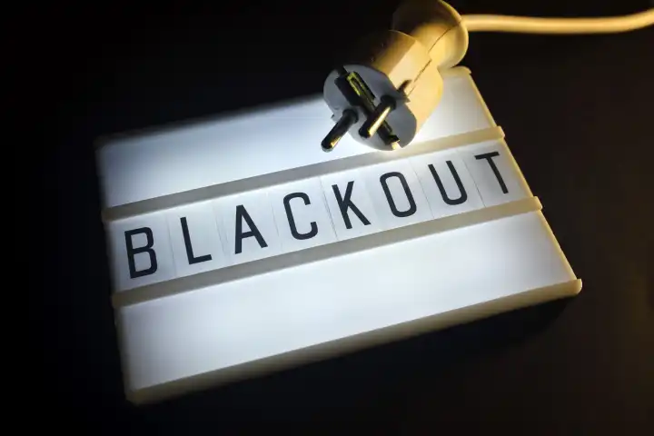 Leuchttafel mit der Aufschrift Blackout und Stecker, Symbolfoto für großflächigen Stromausfall
