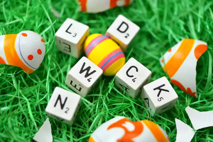 Buchstaben formen das Wort Lockdown in einem Osternest mit zerbrochenem Osterei, Symbolfoto harter Lockdown zu Ostern