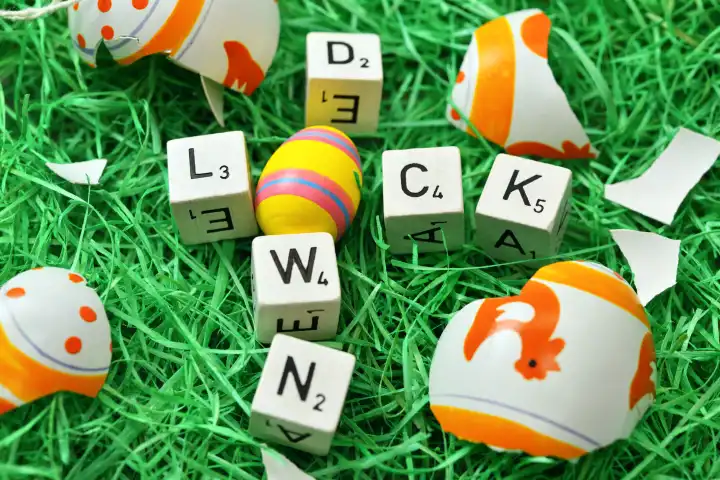Buchstaben formen das Wort Lockdown in einem Osternest mit zerbrochenem Osterei, Symbolfoto Oster-Lockdown