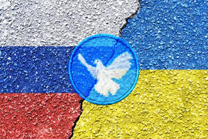 Fahnen von Russland und der Ukraine mit Riss und Friedenssymbol, Symbolfoto Friedensplan für die Ukraine