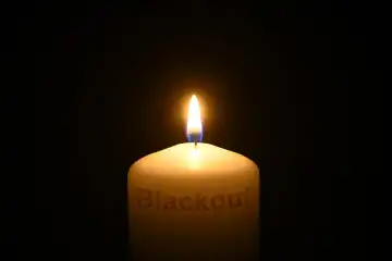 Burning candle with writing Blackout