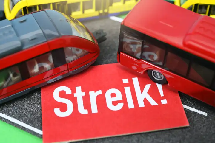 Minitaturen von Bus und Bahn mit einem Streik-Schild, Streik im ÖPNV