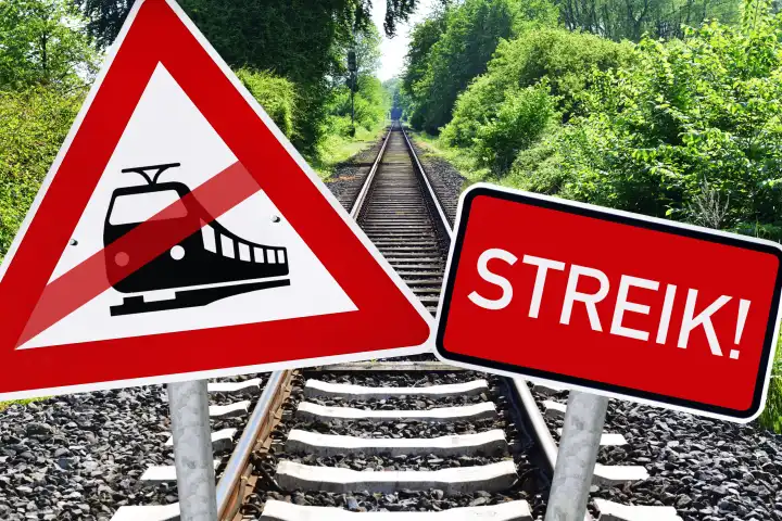 Durchgestrichenes Bahnschild und Schild mit Aufschrift Streik vor leeren Eisenbahnschienen, Symbolfoto Bahnstreik