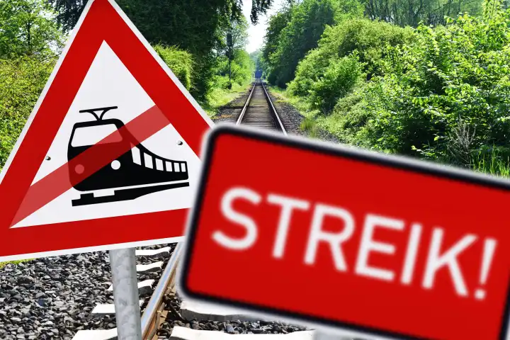 Durchgestrichenes Bahnschild und Schild mit Aufschrift Streik vor leeren Eisenbahnschienen, Symbolfoto Bahnstreik