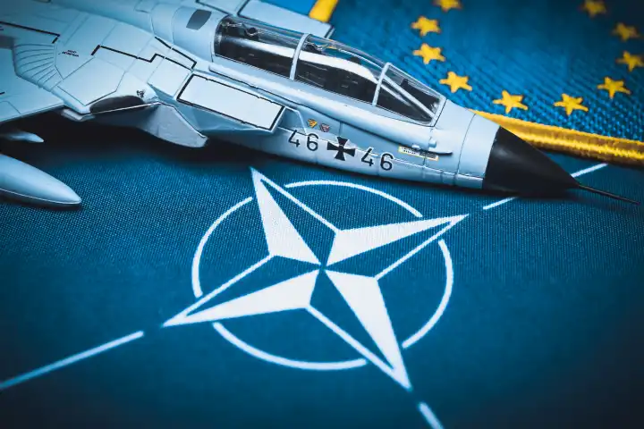 Military jet model on NATO flag, symbol photo Air Defender 2023 NATO air maneuver