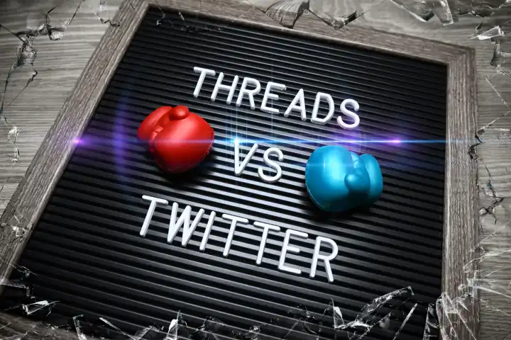 Auf einer Tafel mit Boxhandschuhen steht Threads vs Twitter, neuer Kurznachrichtendienst Threads will Twitter Konkurrenz machen