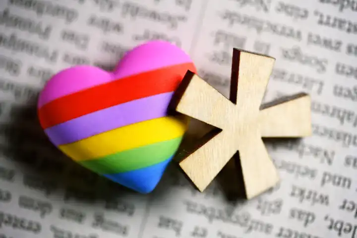 Gender star with heart in rainbow color on newspaper page, symbol photo gender language