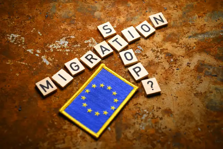 Schriftzüge Migration und Stop mit Fragezeichen neben EU-Fahne, Symbolfoto Migrationskrise