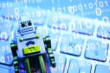 Robot figure lies on a computer keyboard, symbol photo artificial intelligence, photomontage