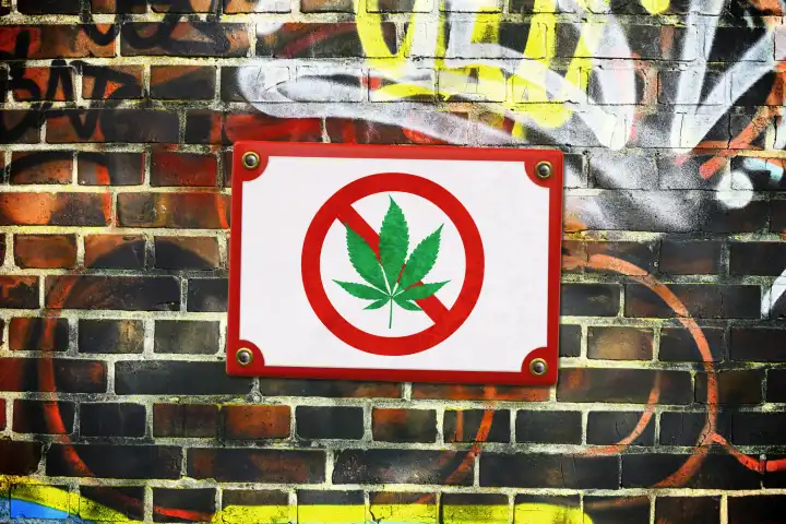 Schild mit durchgestrichenem Cannabisblatt an einer Mauer, Cannabis-Verbot, Fotomontage