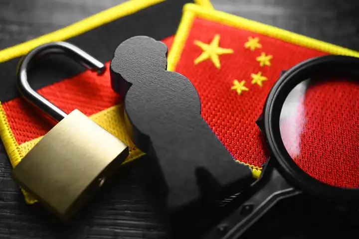 Black figure on the flags of Germany and China, symbolic photo of Chinese espionage