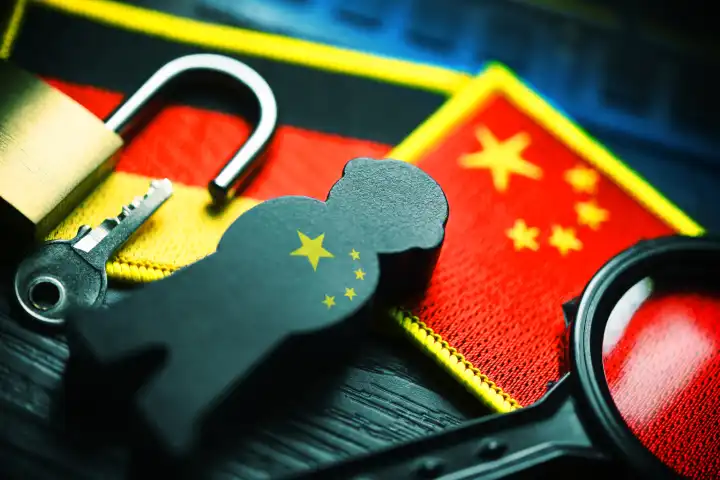 Schwarze Figur auf den Fahnen von Deutschland und China, Symbolfoto chinesische Spionage, Fotomontage