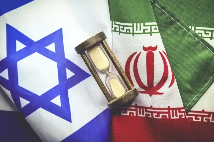 Sanduhr auf den Fahnen von Israel und dem Iran, Nahost-Konflikt