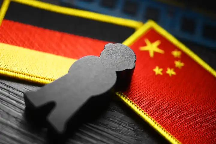 Black figure on the flags of Germany and China, symbolic photo of Chinese espionage