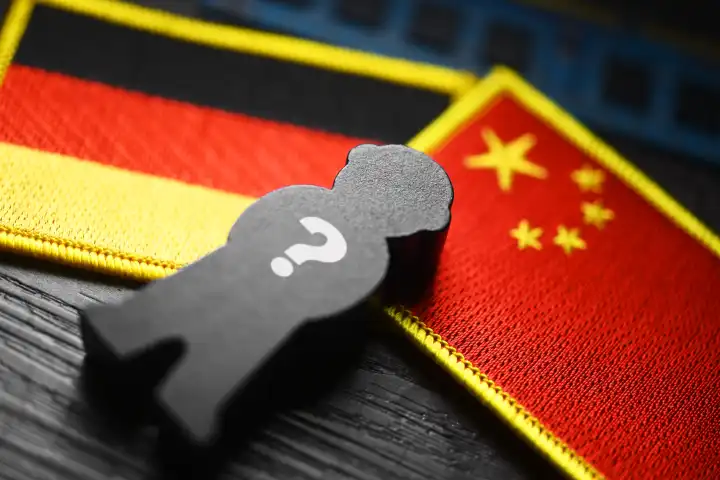 Schwarze Figur mit Fragezeichen auf den Fahnen von Deutschland und China, Symbolfoto chinesische Spionage, Fotomontage
