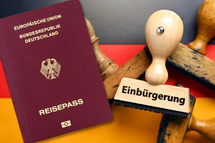 Stempel mit Aufschrift Einbürgerung auf deutscher Fahne und deutscher Pass, Gesetz zur Modernisierung des Staatsangehörigkeitsrechts, Fotomontage