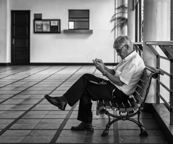 Senior sitting on a wooden bench in a market hall in Madeira