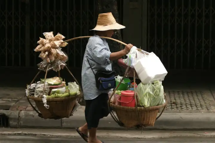 Thailändischer Händler trägt Lebensmittel