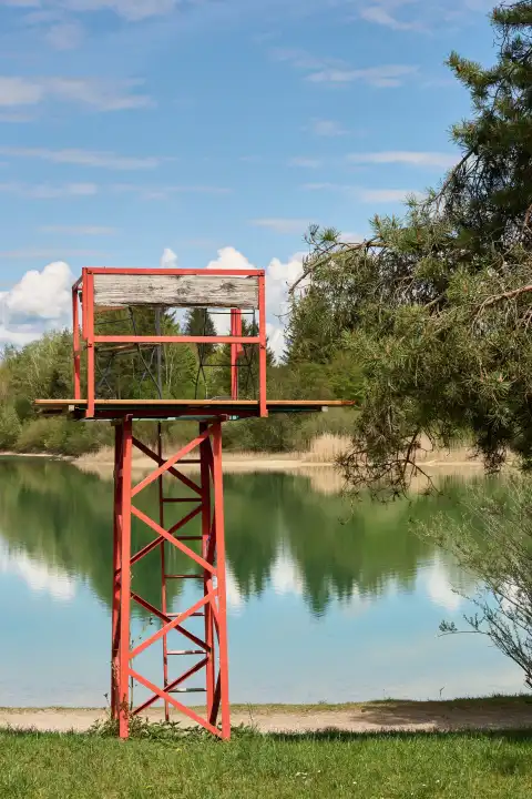 Decommissioned lookout place form water rescue with beer bench and wooden folding chairs at the bathing lake. Whimsical, quirky look.