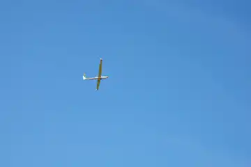 Segelflugzeug mit sichtbarem Kunststoffseil vom Start mit blauen Himmel.