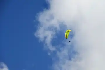 Tandem paraglider high in slightly cloudy sky, Ovronnaz, Valais, Switzerland