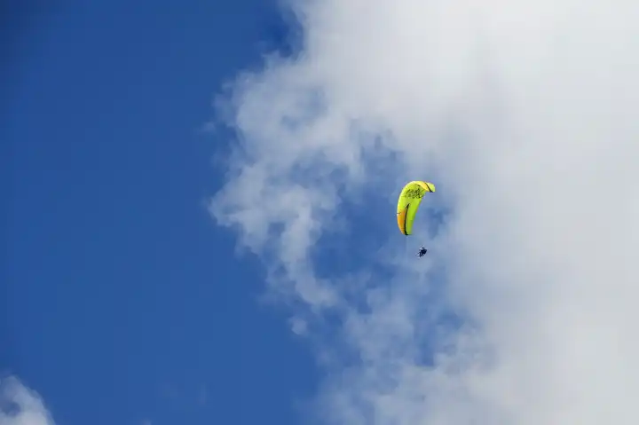 Tandem Gleitschirmflieger hoch am leicht bewölkten Himmel, Ovronnaz, Wallis, Schweiz