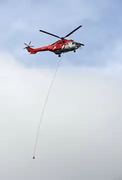 Mehrzweck-Transporthelikopter AS 332 Super Puma C1 HB-XVY der Firma Heliswiss International AG mit einer Transportleine am Rumpf, Wallis, Schweiz