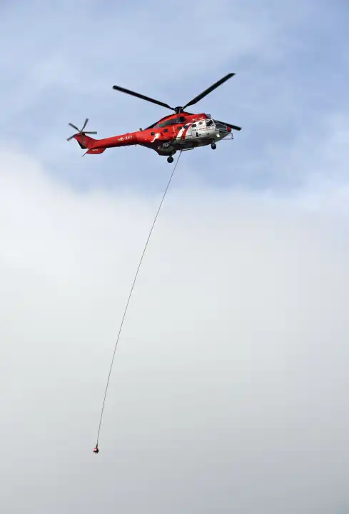 Mehrzweck-Transporthelikopter AS 332 Super Puma C1 HB-XVY der Firma Heliswiss International AG mit einer Transportleine am Rumpf, Wallis, Schweiz