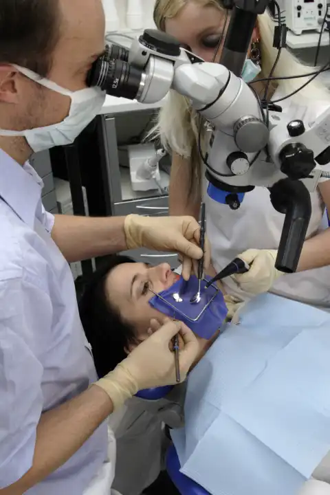 Dental treatment with a cofferdam and microscope