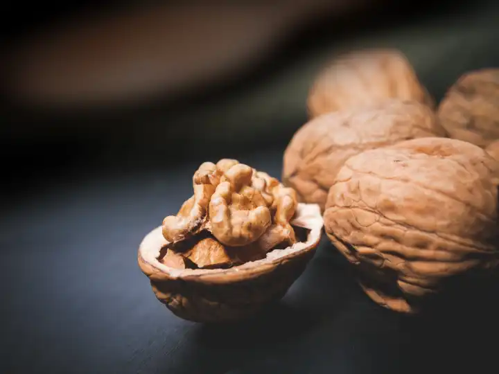 varios walnuts in the table, one is open