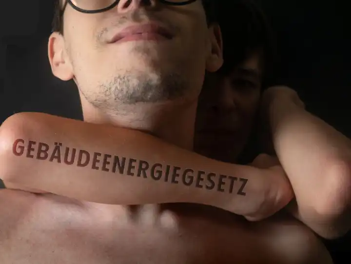 Arm with the inscription "Building energy law, GEG" strangles a person, person in a chokehold