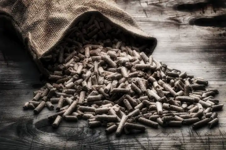 Wood pellets with jute sack on rustic wooden background
