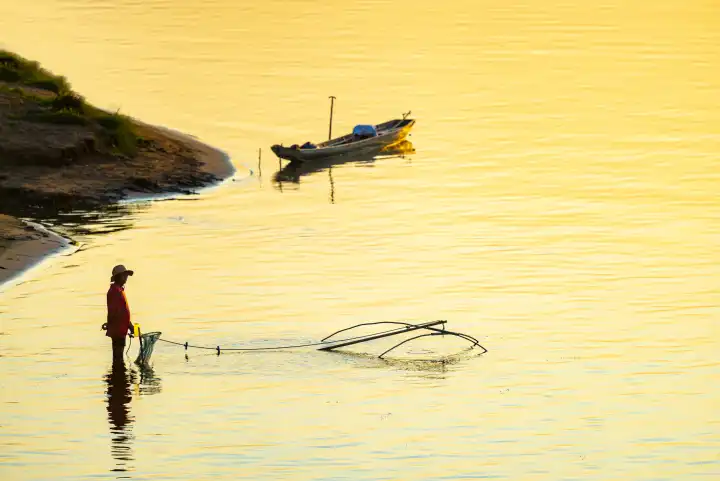 Fischer mit Senknetz bei Sonnenuntergang am Mekong, Luang Prabang, Laos, Asien